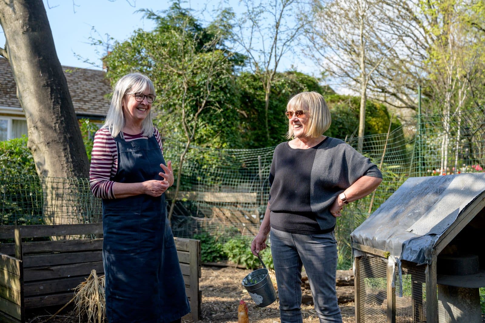 Zwei Seniorinnen lachen gemeinsam im Garten