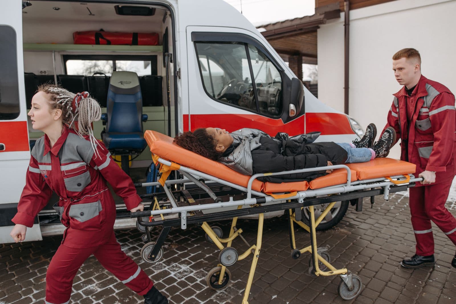 Zwei Sanitäter transportieren eine Patientin sicher auf einer Trage